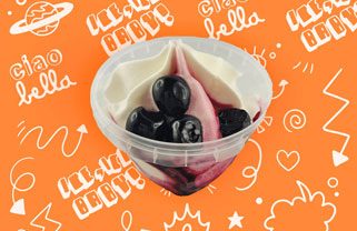 Amarena Becher Sahneeis in einem Becher, garniert mit dunklen Früchten auf einem orangenen Hintergrund.